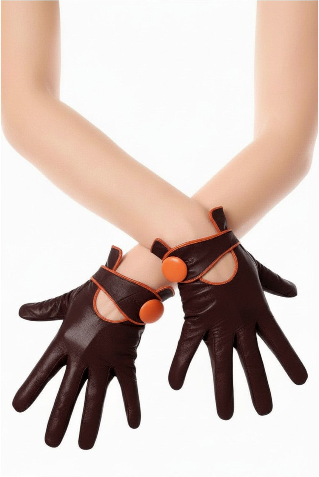 A pair of dark brown genuine leather gloves with side orange button shown cross arm on a model's hands against a white background.
